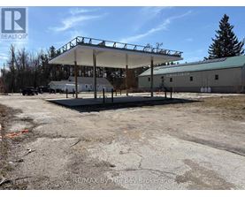 A large, empty parking lot with a gas station and a building in the background.