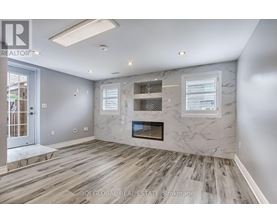 A spacious living room with a fireplace and wood flooring.