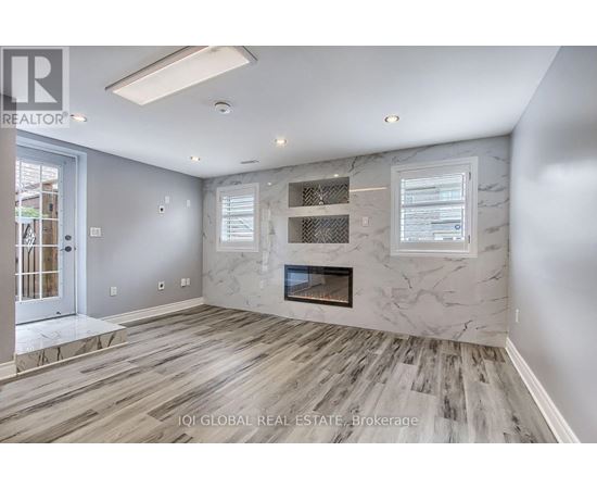 A spacious living room with a fireplace and wood flooring.