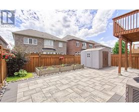 A backyard with a patio and a wooden fence.