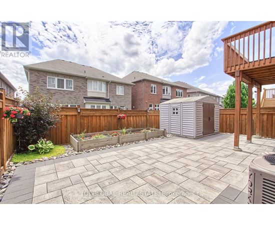A backyard with a patio and a wooden fence.