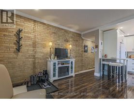 A living room with a brick wall and a television.