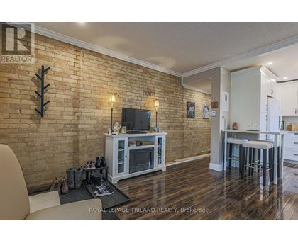 A living room with a brick wall and a television.