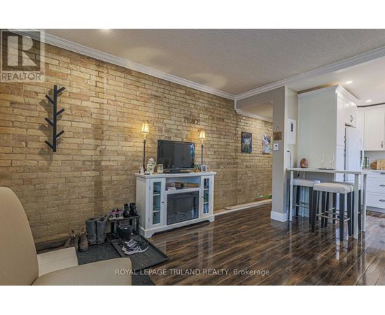 A living room with a brick wall and a television.