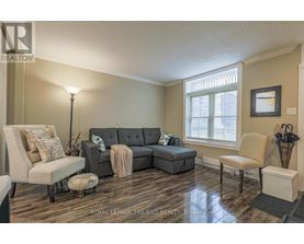 A living room with a grey couch and a lamp.