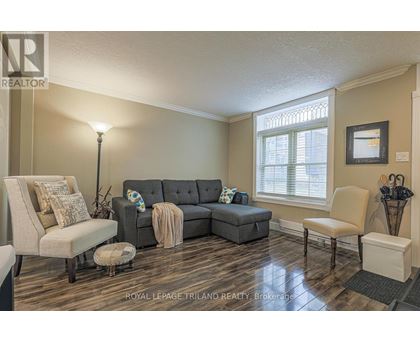 A living room with a grey couch and a lamp.