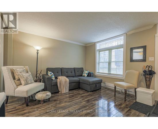 A living room with a grey couch and a lamp.