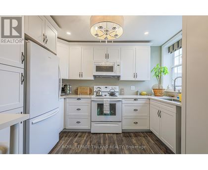 A kitchen with white cabinets and a wooden floor.