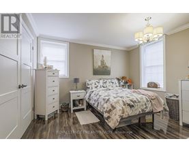 A bedroom with a bed, nightstand, and a chandelier.