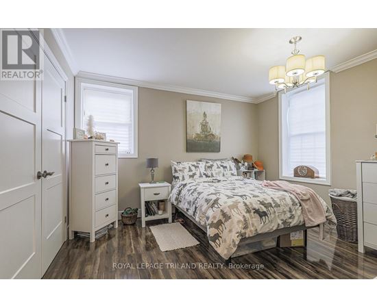 A bedroom with a bed, nightstand, and a chandelier.
