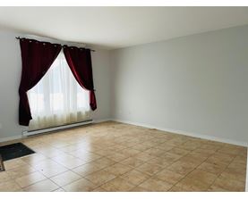 A room with a window covered by red curtains.