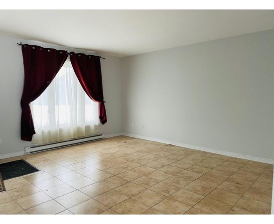 A room with a window covered by red curtains.