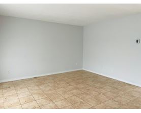 A room with a tiled floor and a light switch on the wall.