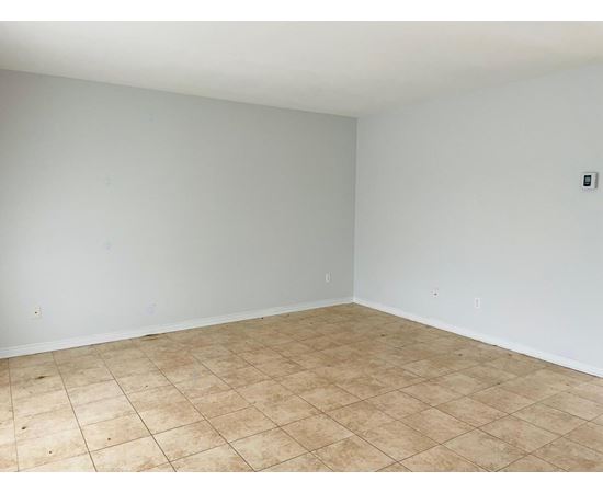 A room with a tiled floor and a light switch on the wall.