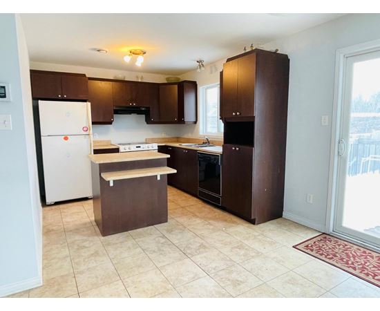 A kitchen with brown cabinets and a white refrigerator.