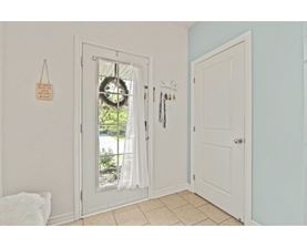 A white door with a glass window and a wreath on it.