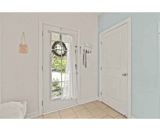 A white door with a glass window and a wreath on it.