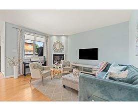 A living room with a grey couch and a fireplace.