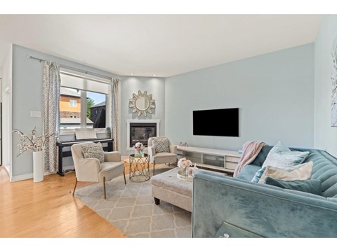 A living room with a grey couch and a fireplace.