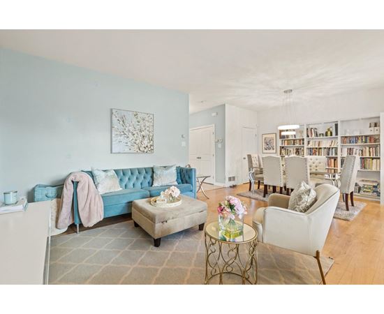 A living room with a blue couch and a white chair.