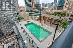 A small pool is surrounded by a balcony with a chair and a table.