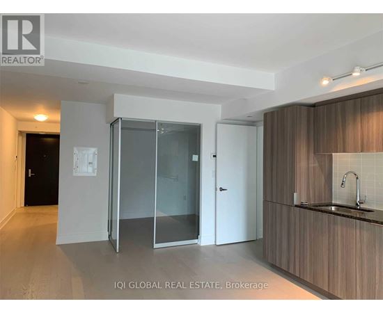 A modern kitchen with a sink and a glass door cabinet.