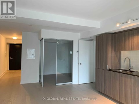 A modern kitchen with a sink and a glass door cabinet.