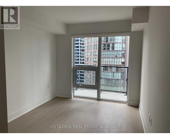 A room with a large window and a view of a building outside.