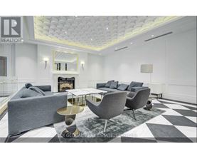 A modern living room with a grey sofa, a coffee table, and a fireplace.