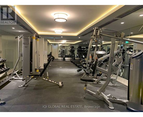A gym with a variety of equipment including treadmills, weights, and exercise machines.