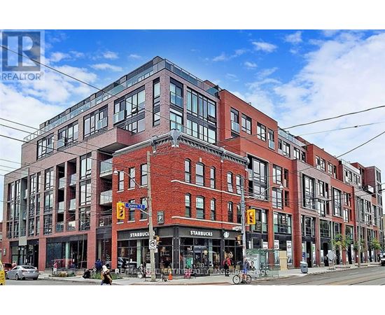 A large red brick building with a Starbucks on the ground floor.