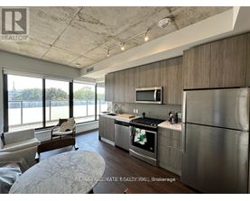 A modern kitchen with stainless steel appliances and a large window.