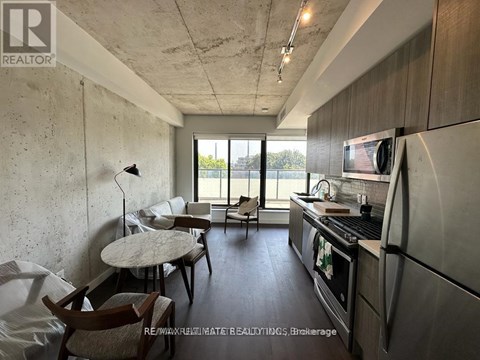A kitchen with a table and chairs in front of a window.