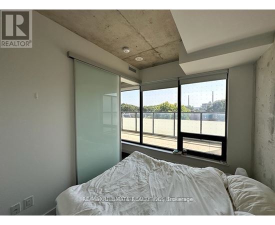 A bedroom with a large bed and a view of a parking lot through the window.