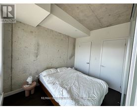 A bedroom with a bed, nightstand, and two doors.