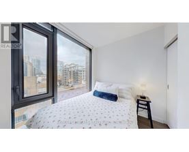 A bedroom with a large bed and a view of the city.