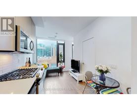 A modern kitchen with a stove top oven and a glass table with a vase of flowers on it.