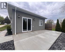 A grey house with a white door and windows is for sale.