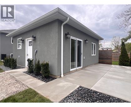 A grey house with a white door and windows.