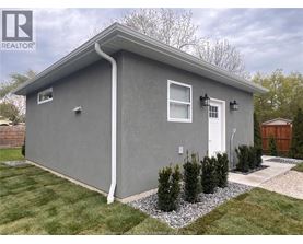A grey house with a white door and windows.