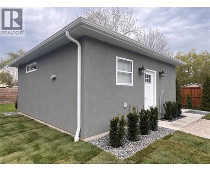A grey house with a white door and windows.