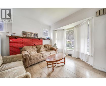 A living room with a red brick fireplace and a wooden coffee table.