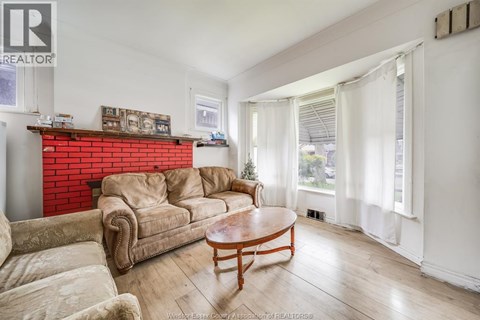A living room with a red brick fireplace and a wooden coffee table.