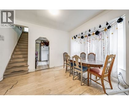 A dining room with a wooden table and chairs.