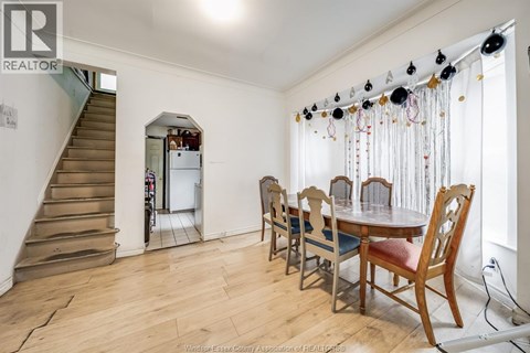 A dining room with a wooden table and chairs.