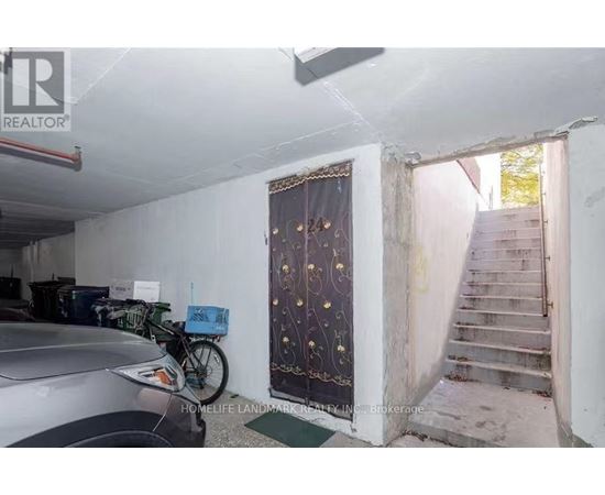 A car is parked in a garage with a bicycle leaning against the wall.