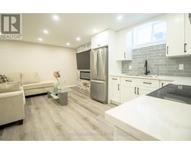 A modern kitchen with a refrigerator, sink, and cabinets.