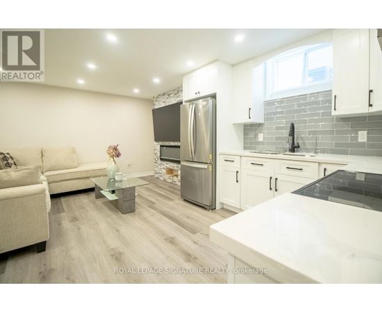 A modern kitchen with a refrigerator, sink, and cabinets.
