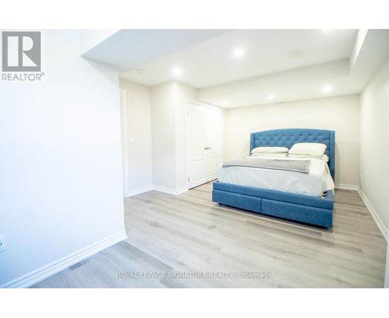 A bedroom with a blue headboard bed and white walls.