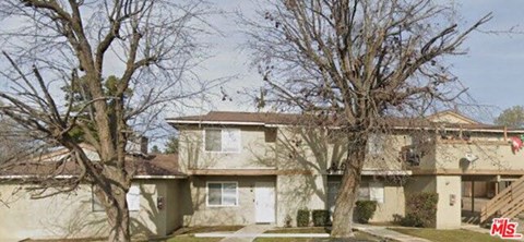 A large house with a tree in front of it.